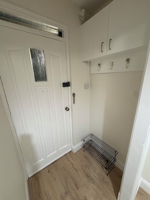 A white door with a small window, a metal rack, and a wooden floor. - Edinburgh castle view apartment newly renovated (4 people) (Edinburgh)