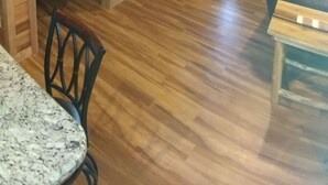 A wooden interior with a deer head mounted on the ceiling, a dining area with a marble table, and a leather sofa. - This cabin is recently constructed and finished November 2016. (Banner Elk)