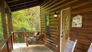 A wooden cabin with a porch, two rocking chairs, and a welcome sign. - This cabin is recently constructed and finished November 2016. (Banner Elk)