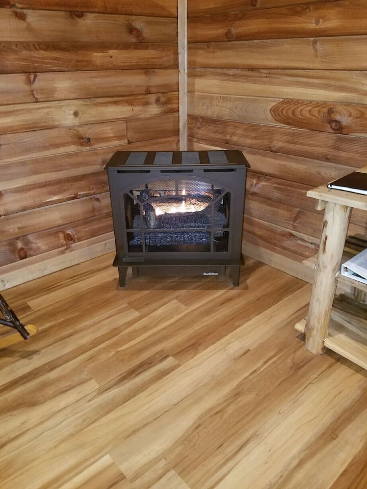 Ein Kaminofen in einer Blockhütte mit Holzwänden und Holzböden.