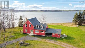 A red house with a garage, a driveway, and a grassy yard. - Rustic waterfront farmhouse on Sydney Harbour, with amazing sunset views. (Point Edward)