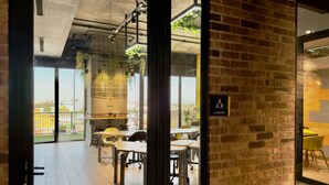 An office space with a brick wall, large windows, and a view of the city.