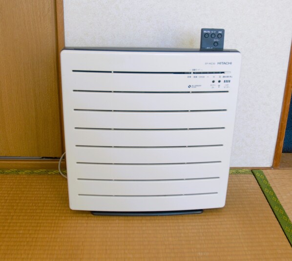 A white portable air conditioner with horizontal vents and a control panel on top.