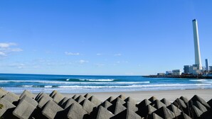 A coastal view with a lighthouse and industrial buildings in the background. - Villa Iwasawa (Hirono)