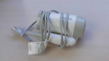 A white power adapter with a plug and a coiled cable on a wooden surface.