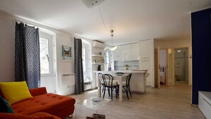 Un appartamento moderno con un soggiorno luminoso, una cucina e un bagno.