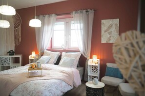 A bedroom with a bed, bedside tables, a chair, and a window with curtains. - Aman private Jacuzzi, billiards and relaxation room (Mulhouse)