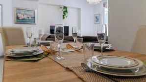 A dining table set with plates, glasses, and cutlery, with a sofa and television in the background. - A2 comfortable apartment with terrace and garden, 4 min walk to Znjan beach (Split)