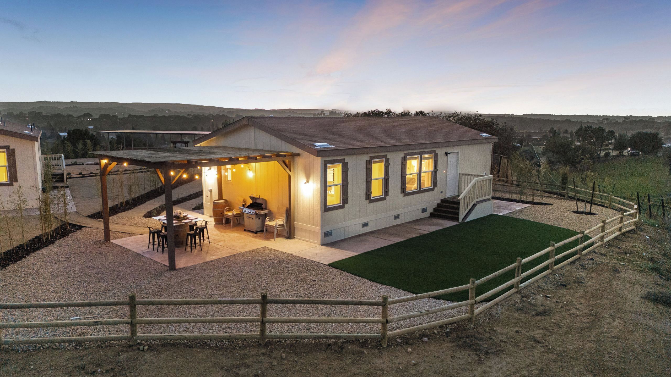 Una casa con patio, mobiliario exterior y zona de barbacoa.