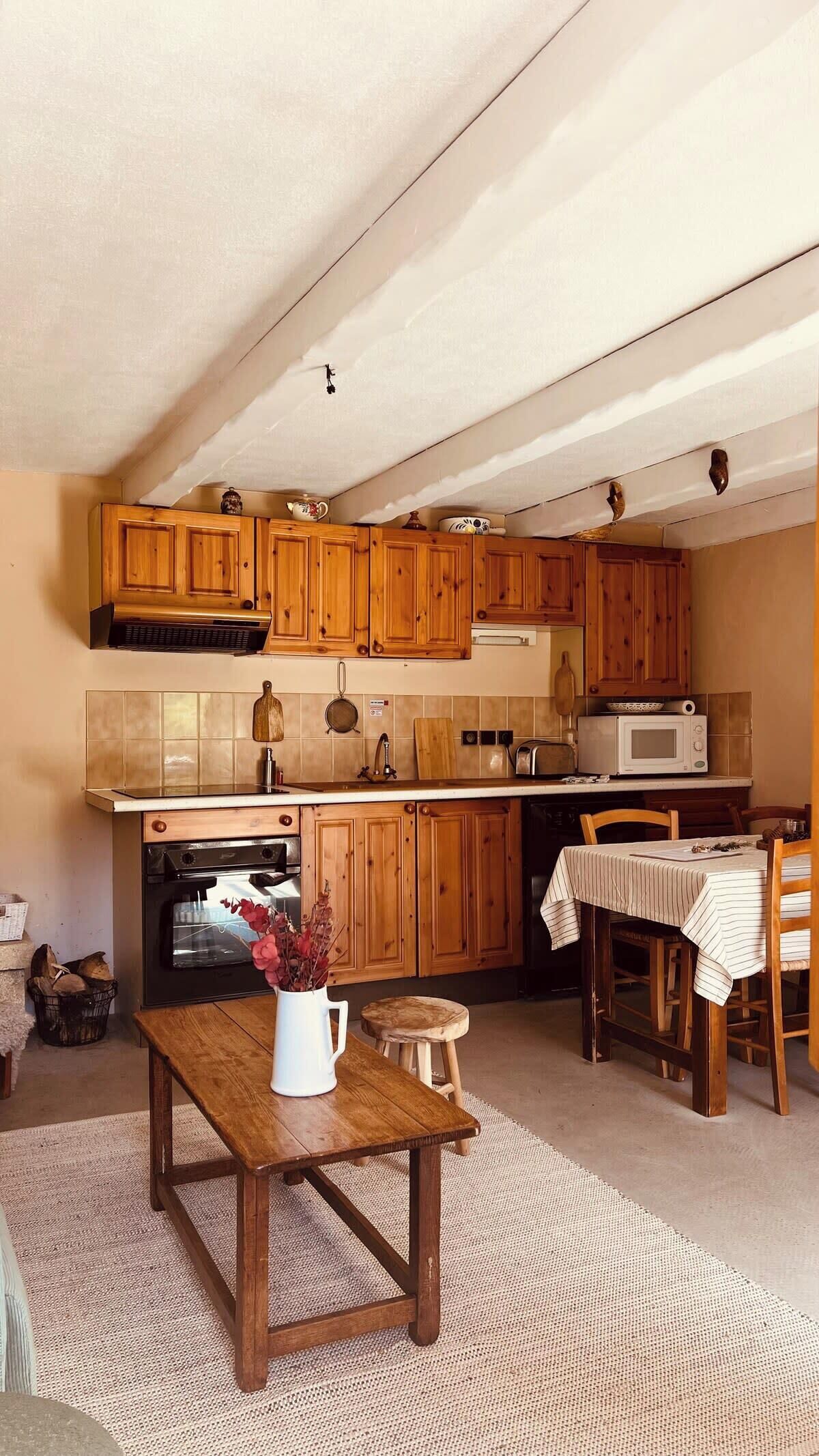 A kitchen with wooden cabinets, a microwave, a stove, and a dining area with a table and chairs.