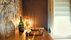 Ein Holztisch mit einer Weinflasche, einem Glas und einem Teller Essen.