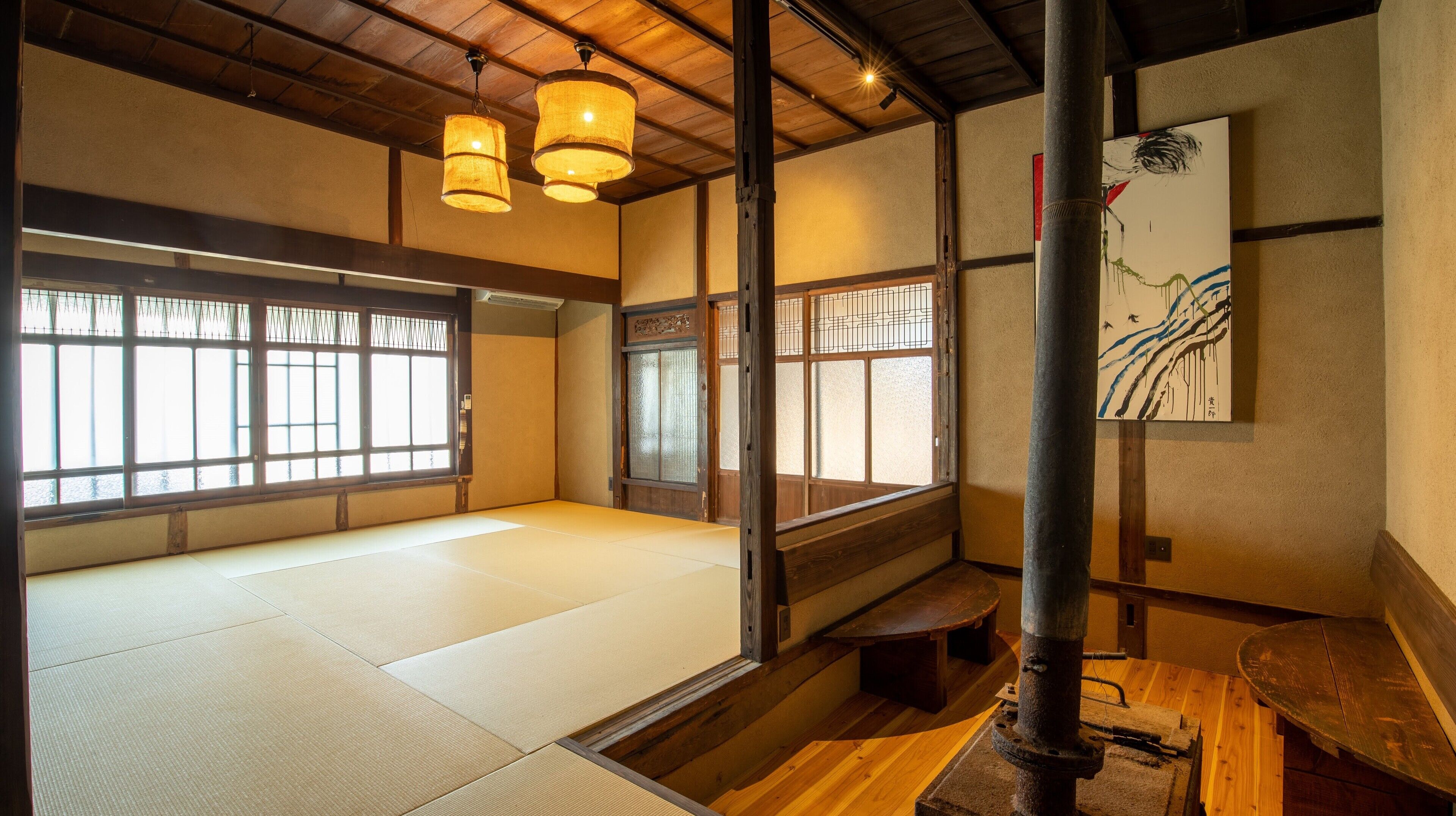 Um quarto tradicional japonês com tatames, biombos shoji e teto com vigas de madeira.