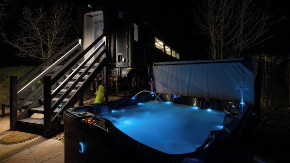 A hot tub with a blue light, a staircase, and a covered area. - Unusual & tranquil. The Carriage Ely is a beautiful railway carriage & hot tubs (ELY)