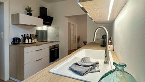 Une cuisine moderne dotée d’un îlot central, d’un four encastré et d’un robinet élégant.