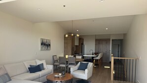 Un salon moderne avec un canapé, une table basse et un coin repas.