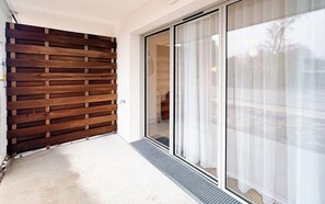 Ein modernes Gebäude mit einer Holz-Lamellenwand, einer Schiebetür aus Glas und einem Betonboden.