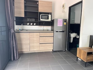 A compact kitchen with a microwave, refrigerator, and sink. - Lotus Bleu Resort & Restaurant (Rawai)