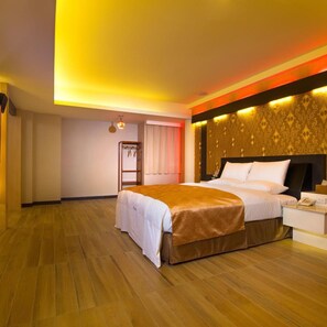 Een hotelkamer met een groot bed, een nachtkastje met een lamp en een kledingkast.