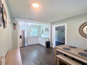A modern kitchen with white cabinets, a stainless steel refrigerator, and a window with a view. - Nest on Newell - Centrally Located (Jacksonville)