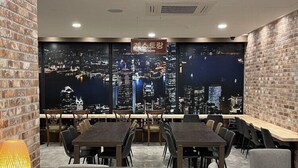 En restaurang med utsikt över staden, väggar i tegel och moderna möbler.