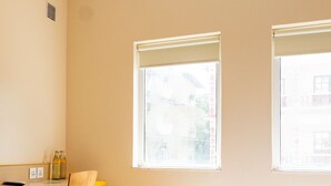 A room with a bed, a desk, and two windows. - Bloomrooms @ Calangute (Candolim)
