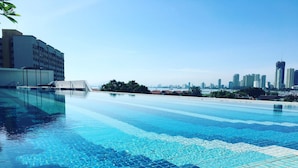 A swimming pool with clear blue water, surrounded by modern buildings and a city skyline in the background. - The Landmark Studio Suite (George Town)