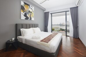 A modern hotel room with a large bed, a nightstand, a painting on the wall, and a view of the city through the window. - The Landmark Studio Suite (George Town)