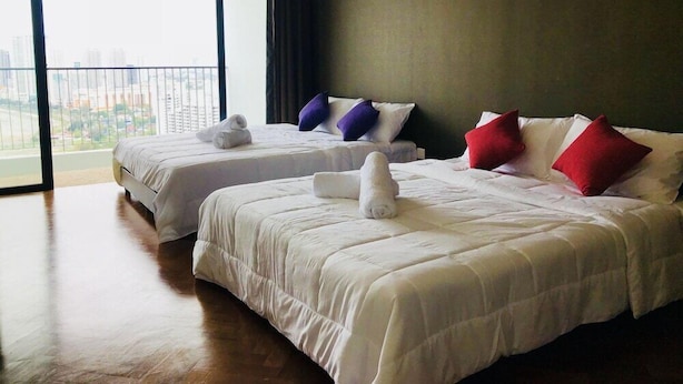 A hotel room with two beds, a large window with a city view, and a balcony. - The Landmark Studio Suite (George Town)