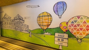 A mural with hot air balloons, a bus, and a building labeled 'Luye'. - Traveller-inn Tiehua Cultural and Creative Hotel (Taitung)