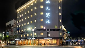 A multi-story hotel with illuminated signage and a well-lit entrance. - Traveller-inn Tiehua Cultural and Creative Hotel (Taitung)