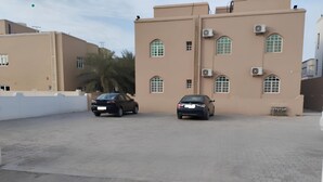 A building with a flat roof, multiple windows, and air conditioning units.
