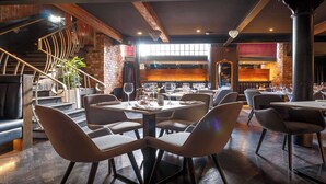 A modern restaurant with a mix of seating options, including tables and booths, and a visible staircase leading to an upper level. - Velvet Hotel Manchester, Worldhotels Crafted (Manchester)