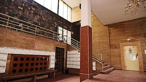 A spacious lobby with a high ceiling, a staircase, and a mural on the wall. - Absolut City Hostel Budapest (Budapest)
