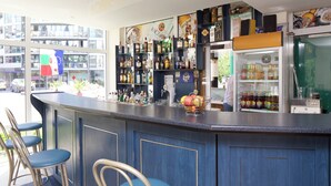 A bar area with a counter, stools, and shelves of bottles.