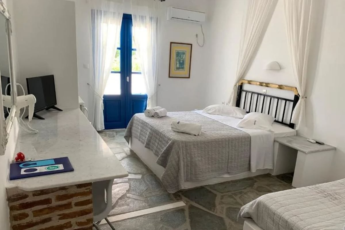A bedroom with a bed, bedside table, and a desk with a chair.