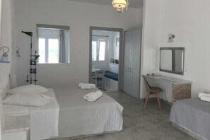 Um quarto com cama, escrivaninha, cadeira, espelho e guarda-roupa.