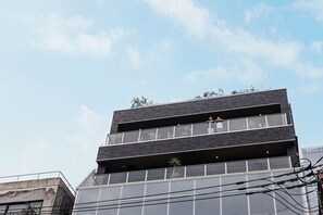 A multi-story building with a modern architectural design, featuring large windows and balconies. - H Daimyo (Fukuoka)