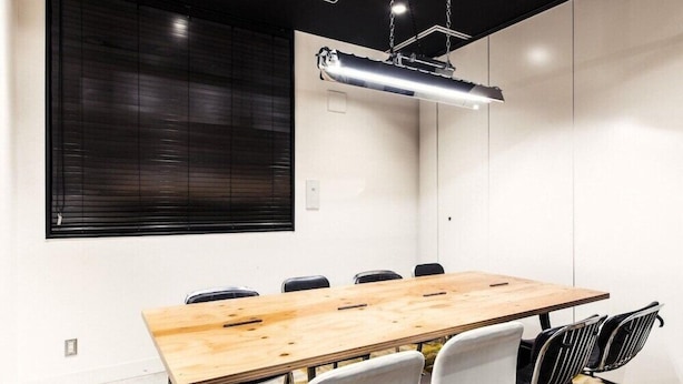 A conference room with a long wooden table, six chairs, and a modern pendant light. - H Daimyo (Fukuoka)