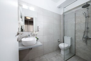 Une salle de bain moderne avec une douche à parois de verre, un lavabo blanc et des toilettes.