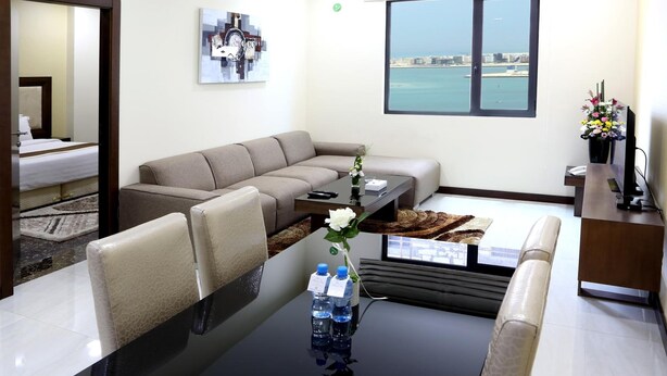 Un salon moderne avec un canapé, une table basse et une vue sur la mer.