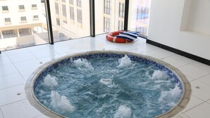 Un bain à remous avec vue sur les bâtiments, grâce à de grandes fenêtres.