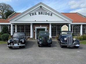 A building with a sign reading 'THE BRIDGE' and three vintage cars parked in front. - The Bridge Hotel And Spa (Wetherby)