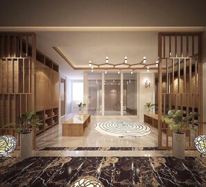 A modern lobby with a marble floor, wooden paneling, and a central light fixture. - Alansea Danang Hotel (Da Nang)