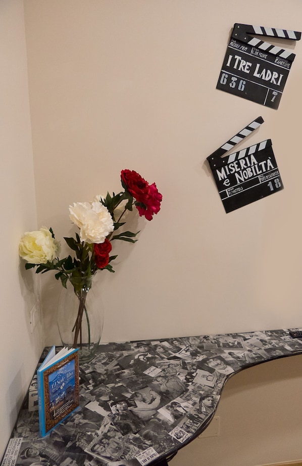 A table with a book titled "O Sole Mio" and a vase with flowers. - B&B City Soul Typical Resort (Naples)