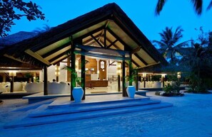 Ein Resort mit überdachtem Empfangsbereich, Außenbestuhlung und einem Pool.