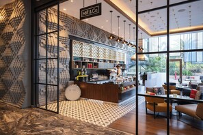 Un interior moderno con una zona de bar, asientos y vistas amplias a través de grandes ventanales.