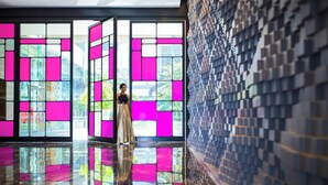 A modern interior with a reflective floor, large windows with pink and white panels, and a patterned wall. - Renaissance Ahmedabad Hotel (Ahmedabad)