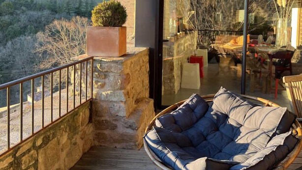 A modern outdoor seating area with a wicker chair and a view of a mountainous landscape. - Le Pailler - DIO-ET-VALQUIERES (DIO-ET-VALQUIERES)