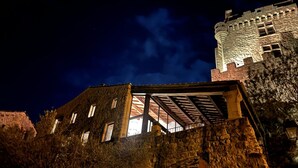 A stone building with a tower, large windows, and a covered area with a roof. - Le Pailler - DIO-ET-VALQUIERES (DIO-ET-VALQUIERES)