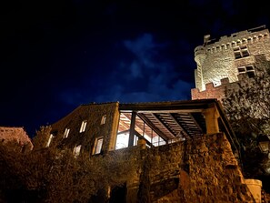 A stone building with a tower, large windows, and a covered area with a roof. - Le Pailler - DIO-ET-VALQUIERES (DIO-ET-VALQUIERES)